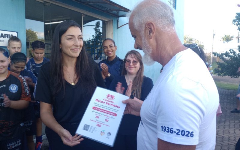 Juíza Rebecca Roquetti Fernandes entrega placa da campanha dos bancos vermelhos para o presidente do Aimoré Ronaldo Vieira