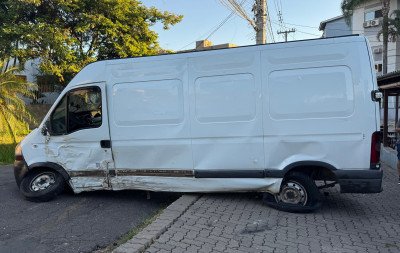 Van desce lomba de ré e bate em carro e árvore após motorista perder controle da direção
