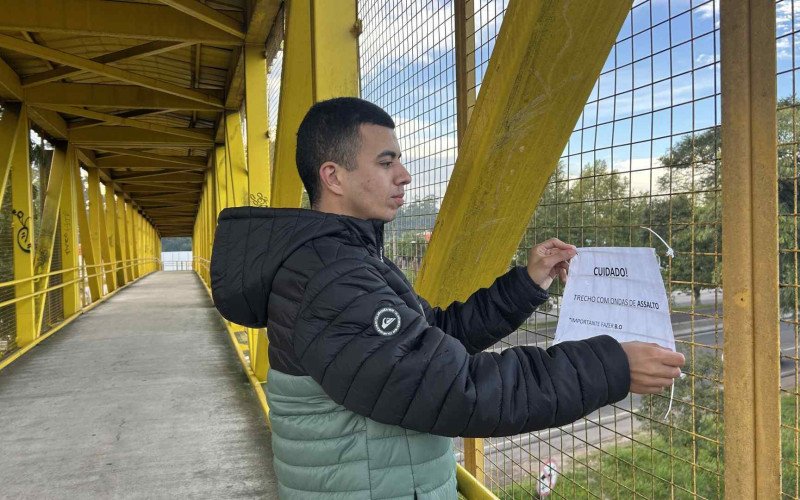 Anderson Fernandes tomou a iniciativa de colocar cartazes com alerta para o risco de assaltos na passarela José de Quadros | abc+