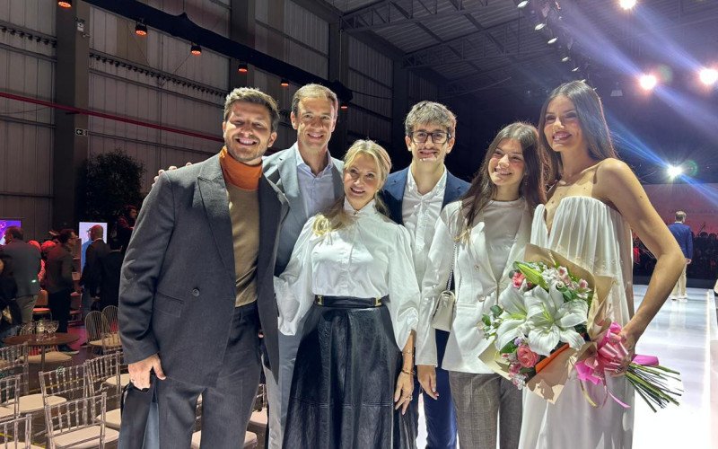 Kleber toledo (à esquerda) e Camila Queiroz (à direita), com nomes da empresa (centro) participaram do Fashion Experience da Beira-Rio