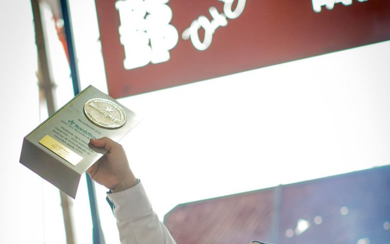 Chef Edi Dagrê exibe troféu do recorde da maior linguiça do mundo