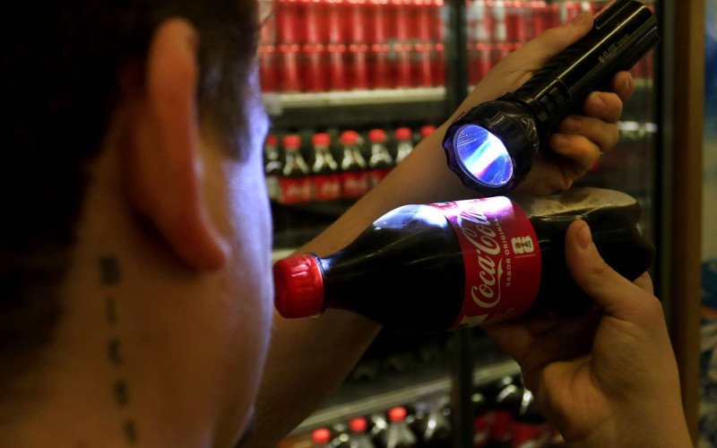 Estratégia usada por colecionadores é usar lanterna para descobrir se a figurinha está ou não no rótulo da Coca-Cola | abc+