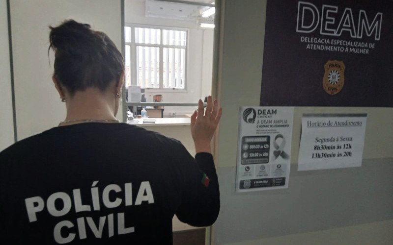 Cartaz colado na porta da Delegacia da Mulher avisa mudança no horário de atendimento, em Canoas | abc+