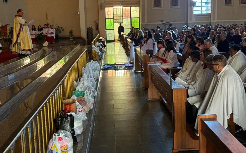 Celebração de Corpus Christi na Paróquia Santa Catarina com tapete de roupas e doações de alimentos