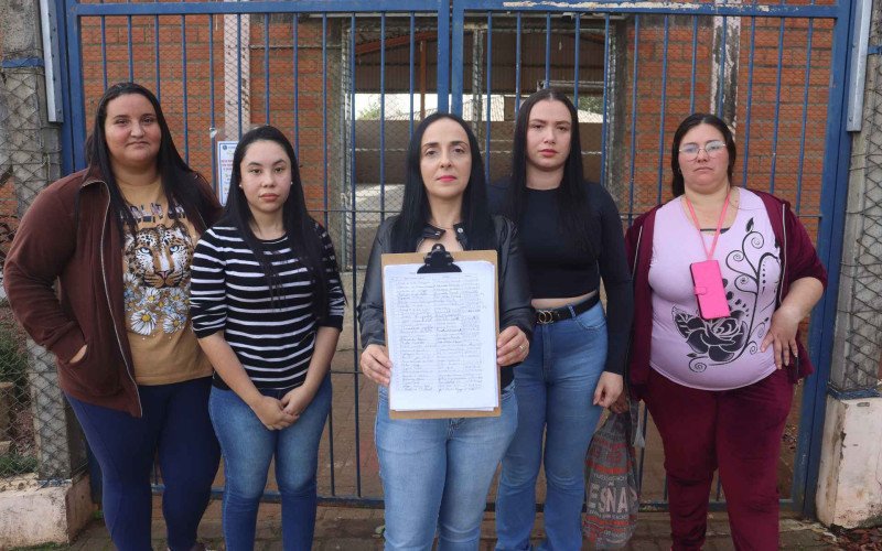 Vitória, Juliana, Luciana (com o papel), Maria Eliane e Maristela reivindicam a manutenção da oferta de turmas de 1º ano do Ensino Fundamental na Emeb Bento Gonçalves | abc+