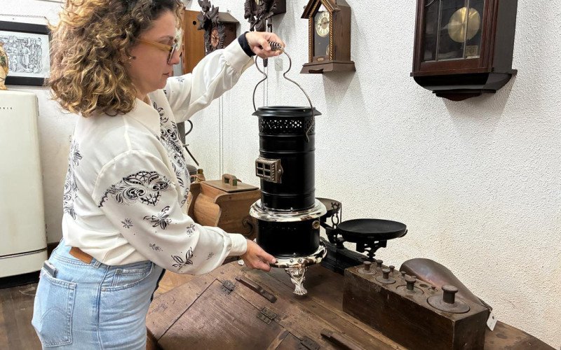 Projeto de restauração de acervo atingido pela enchente no Museu Histórico Visconde de São Leopoldo - Luísa mostra aquecedor metálico a querosene já restaurado 