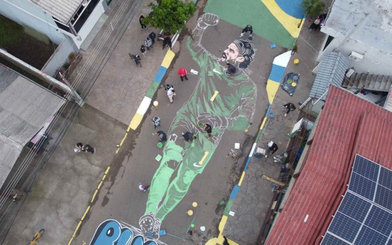 Antes da Copa do Mundo de 2026, o artista Joacaz Santos, com apoio da comunidade, pinta Alisson Becker na rua Costa Rica, no bairro Santo Afonso, em Novo Hamburgo | abc+
