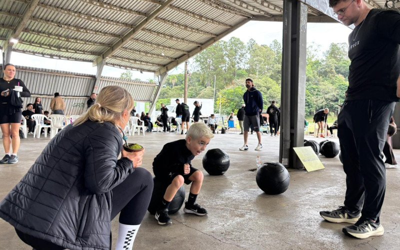 Crianças e adultos participam do PFT, teste de aptidão física da modalidade esportiva Hyrux, que mescla exercícios funcionais com tarefas de força e corrida