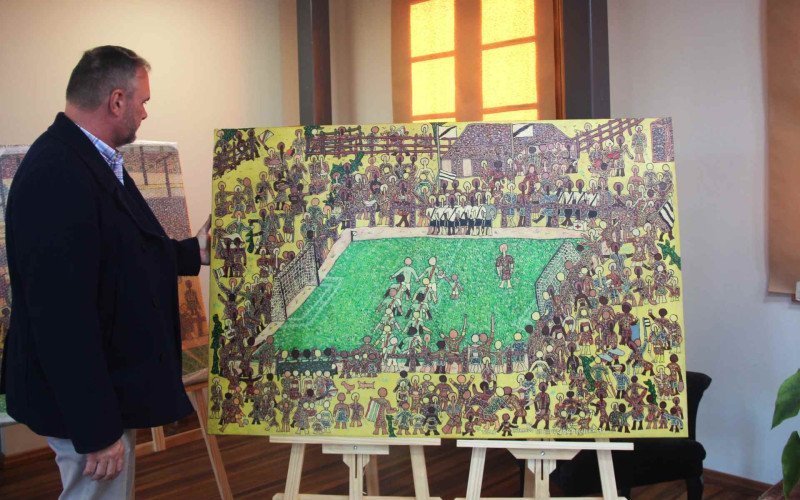 Secretário de cultura observa os detalhes das obras de Carlão