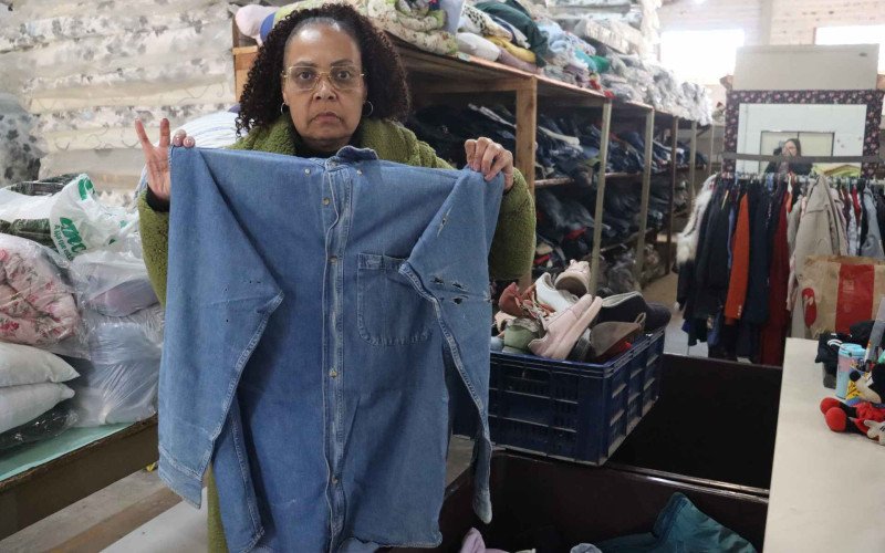 Coordenadora da Fábrica da Cidadania, Jaqueline Andréia da Silva, expondo as peças recebidas na Campanha do Agasalho de Novo Hamburgo | abc+